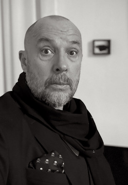 Architektur und die Erinnerung an Arcadien
In den Gemälden von Jens Hausmann verschmelzen Präzision und metaphysische Ahnung.
Seine strengen, fast klinisch klaren Baukörper stehen in Zwielicht getauchten Landschaften,
die gleichermaßen real wie entrückt wirken.
Zwischen Moderne und Verfall, Rationalität und Geheimnis entsteht ein Raum, der die Fragilität
menschlicher Zivilisation spürbar macht. Seine streng konstruierten Räume, losgelöst von jeder
funktionalen Logik, erscheinen wie Modelle einer Ziviisation, die sich selbst überlebt hat.
Zwischen gläserner Klarheit und stiller Verwüstung untersucht Hausmann das Verhälnis von
Mensch, Raum und Natur in einer Epoche, die ihre Utopien hinter sich gelassen hat.
Kompositorische Entscheidungen in den Bildern erzeugen eine Spannung, weil sie das Zentrum
einer möglichen Handlung leer lassen.
Diese Leerstelle ruft beim Betrachter ein Erahnen und Mitdenken hervor, ähnlich wie bei Filmen
von Hitchcock oder David Lynch, wo das Rätselhafte in der Atmospähre selbst liegt.
Er wird zum Zeugen einer Szene, deren Handlung sich in seiner eigenen Vorstellung fortsetzt - ein
malerischer Suspens der das Zeitgefühl des Films in die Stille der Malerei überführt.